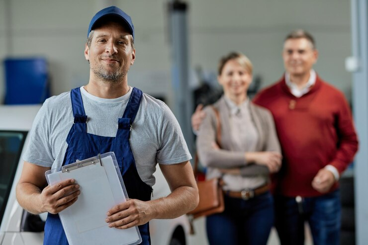 portrait happy auto repairman looking camera while his customers are standing background 637285 7790