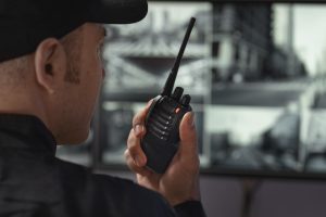 portrait male security guard with radio station camera screens