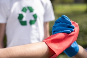 Three men at plastic garbage collecting in a polluted park